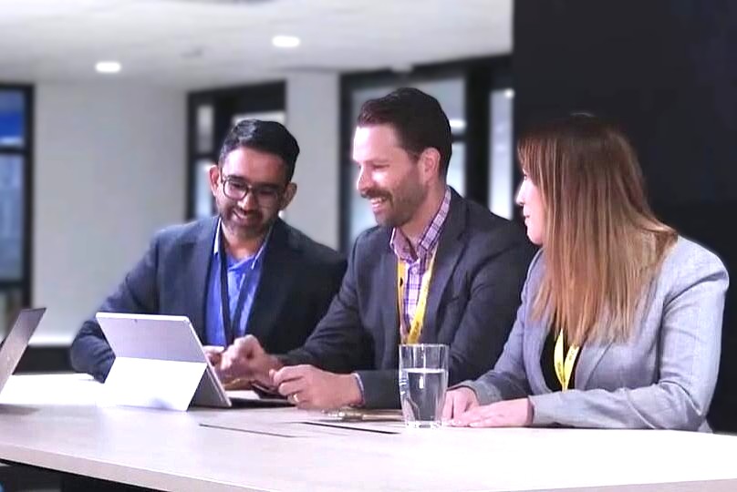 Business people sitting around a table with laptops