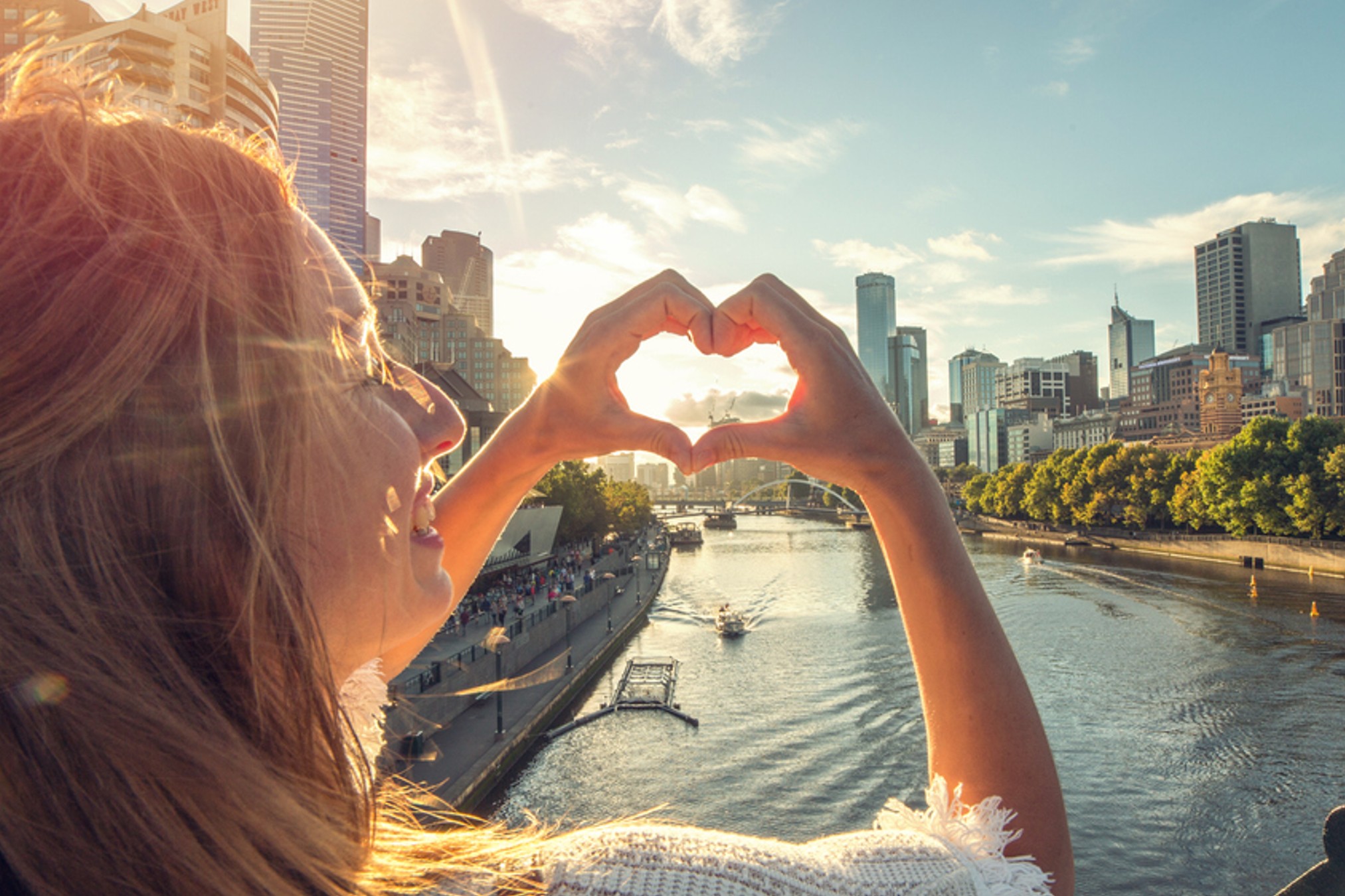 Yarra River Melbourne CBD, woman making heart shape with hands.